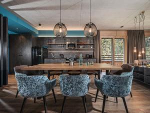 cocina y comedor con mesa de madera y sillas en Sieghard Suites Mayrhofen, en Mayrhofen