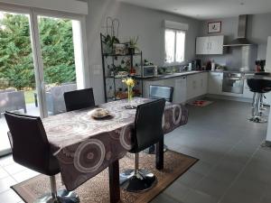 eine Küche mit einem Tisch und einigen Stühlen in einem Zimmer in der Unterkunft Chambre d'hôtes Les Joncs in Brax