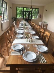 a long wooden table with plates and napkins on it at Zacisze Trzech Gór in Jedlina-Zdrój