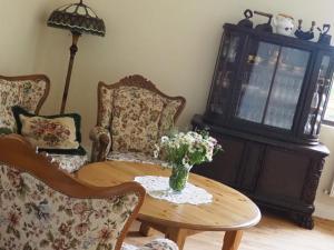 a living room with a table and chairs and a vase of flowers at Zacisze Trzech Gór in Jedlina-Zdrój