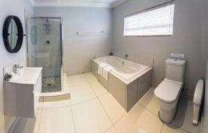 a bathroom with a toilet and a sink and a shower at Villiera Guesthouse in Douglas +42 photos
