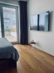 um quarto com uma cama, uma mesa e uma janela em Business Apartments em Brno