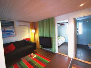 a living room with a couch and a flat screen tv at Stayin Borgafjäll - Tuffa Lillan - Bo bakom hotellet in Borgafjäll