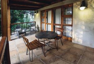 un patio con mesa y sillas en un porche en Villiera Guesthouse, en Douglas