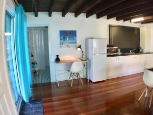 a kitchen with a refrigerator and a table in it at High Tide at Emerald in Emerald Beach