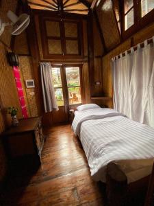1 Schlafzimmer mit 2 Betten in einem Zimmer mit Fenstern in der Unterkunft No. 8 Pai in Pai
