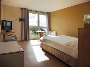 a hotel room with a bed and a large window at Logis Hôtel du Belvédère in Brest