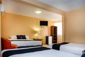 pokój hotelowy z 2 łóżkami i telewizorem z płaskim ekranem w obiekcie Capital O Hotel Dos Mares, Cabo San Lucas w mieście Cabo San Lucas