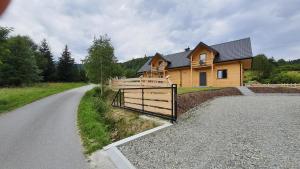a house with a gate on the side of a road at Michałówka Zawoja in Zawoja