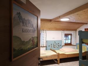 Breitenbach am InnにあるFerienheim Riedhofの二段ベッド2組が備わる客室で、ドアに絵画が飾られています。