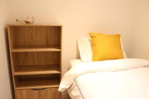 a bedroom with two beds and a book shelf at The Cottage get away in Saffron Walden