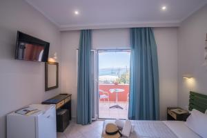 una camera d'albergo con un letto e una porta scorrevole in vetro di Christina Beachfront Rooms By Hotelius a Petrití