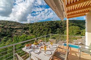 a table on a balcony with a view of a mountain at Kosyforema Villas in Gialova