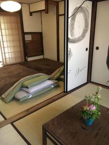 奈良市にあるゲストハウス 奥のベッド1台とテーブルが備わる部屋