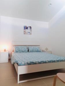 a bedroom with a bed with a blue comforter at VILLA MOGUNTIA in Ficarazzi