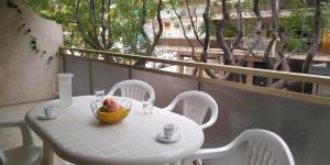 - une table blanche avec un bol de fruits sur le balcon dans l'établissement SCALA Apartaments, à Salou