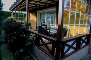 a screened in porch with a table and chairs on it at Całoroczny dom nad morzem in Ostrowo