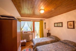 una camera d'albergo con due letti e una finestra di ALTIDO Apt for 7 with Terrace and Exceptional Location a Courmayeur