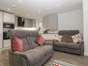 a living room with a couch and a kitchen at Flat 2, 38 Preston Road in Weymouth