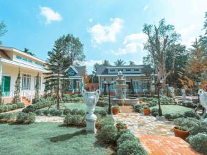 a house with a garden with a fountain at Baroque Boutique Resort in Ranong