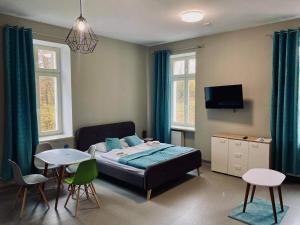 a bedroom with a bed and a table and chairs at Hotel Jedlinka in Jedlina-Zdrój