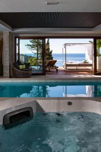 a swimming pool in a house with a view of the ocean at Villa T Dubrovnik - Wellness and Spa Luxury Villa with spectacular Old Town view in Dubrovnik