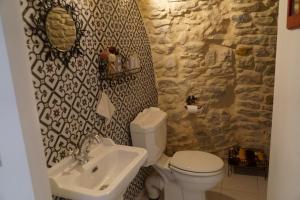 a bathroom with a white toilet and a sink at Gîte à la ferme au Mas du Sire in Quissac