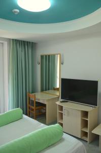 a hotel room with two beds and a flat screen tv at Hotel Iadolina in Stana de Vale