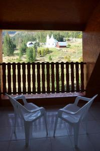 two chairs sitting in front of a window with a bench at Hotel Iadolina in Stana de Vale