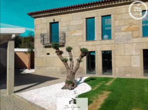 ein Haus mit einem Baum davor in der Unterkunft Cortegaça House in Vieira do Minho