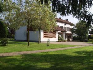 a house with a tree in front of a driveway at B&B Casa Manuelli in Alessandria