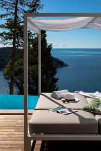 a bed on a deck with a view of the ocean at Villa T Dubrovnik - Wellness and Spa Luxury Villa with spectacular Old Town view in Dubrovnik