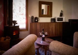 a living room with a table and two glasses of wine at Tomah Retreat - Studio CHILL with fireplace and clawfoot bath in Mount Tomah