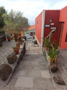 a patio with potted plants and a red building at Casa El Comisario in Tanque