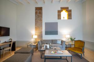 a living room with a couch and a table at Hospes Palacio de Arenales & Spa in Cáceres