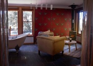 a bathroom with a tub and a couch and a chair at Tomah Retreat - Studio CHILL with fireplace and clawfoot bath in Mount Tomah