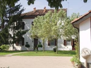 una casa blanca con árboles delante de ella en B&B Casa Manuelli, en Alessandria