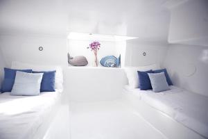 two white beds with blue pillows in a room at Barco Casa Marina Fuzeta in Fuzeta