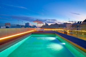 ein Schwimmbad auf dem Dach eines Gebäudes in der Nacht in der Unterkunft Tandem Torres de Cádiz Suites in Cádiz