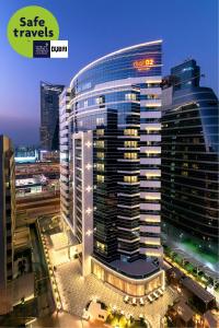 un gran edificio con un cartel en el costado en Dusit D2 Kenz Hotel Dubai, en Dubái