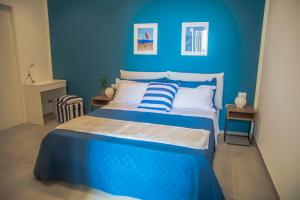 a blue bedroom with a bed with a blue wall at Riflessi DaMare Room & Apartment in Salerno