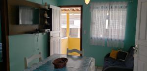 comedor con mesa y ventana en Casas para alugar no Centro de Bombinhas, en Bombinhas