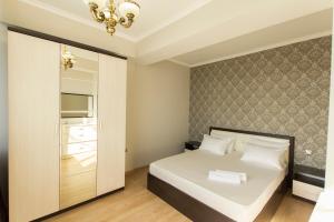 a bedroom with a white bed and a mirror at Residential Сomplex Central 270 in Almaty
