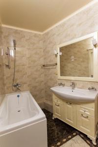 a bathroom with a tub and a sink and a mirror at Residential Сomplex Central 270 in Almaty