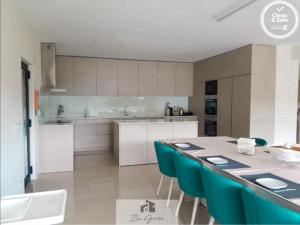eine Küche mit einem Tisch und blauen Stühlen in der Unterkunft ERMAL HOUSE in Braga