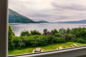 a grassy area with a view of a lake and mountains at The Lodge On The Loch Onich in Onich