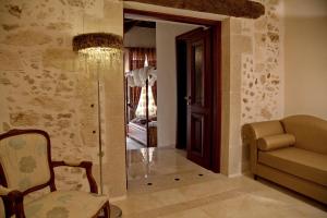 uma sala de estar com um sofá e uma cadeira em Antica Dimora Suites em Rethymno Town