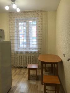 キーロフにあるApartments in Kirov Orlovskaya 4のテーブルと椅子2脚、窓が備わる客室です。