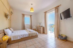 sypialnia z łóżkiem i widokiem na ocean w obiekcie Faro Del Porto w mieście Poros