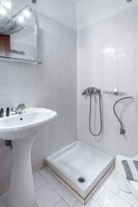 a white bathroom with a sink and a shower at Faro Del Porto in Poros